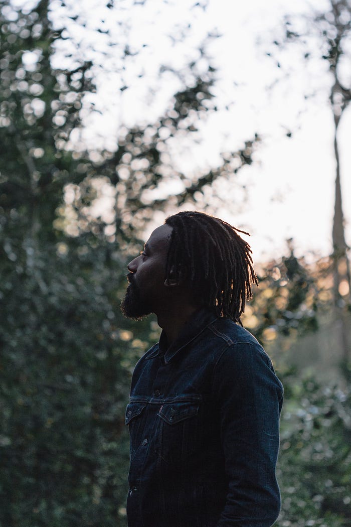 Esiah backlit in the evening light, stands in profile