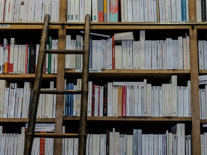 An open book lying on a wooden table, with the morning sun casting a warm glow on its pages.