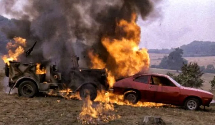 Image of a Ford Pinto and another vehicle on fire. The fire was caused by design defects in the Ford's fuel tank system