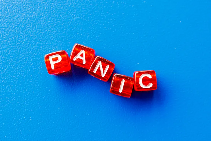 A sky blue background with the word “panic” on red cubed beads with white letters.