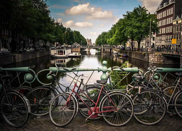 This photo shows bicycles parked in front of a canal in Holland.