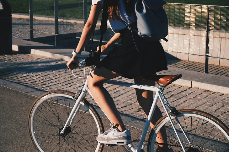 A young girl riding an average ten-speed bike.