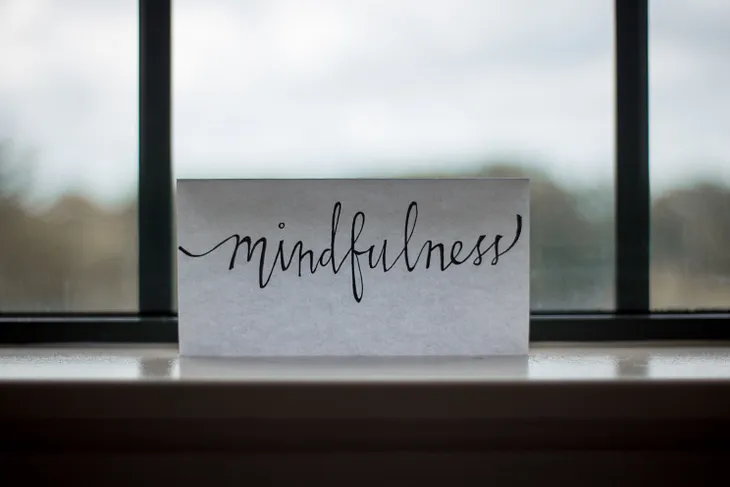 Piece of paper on a windowsill with the word “Mindfulness” on it