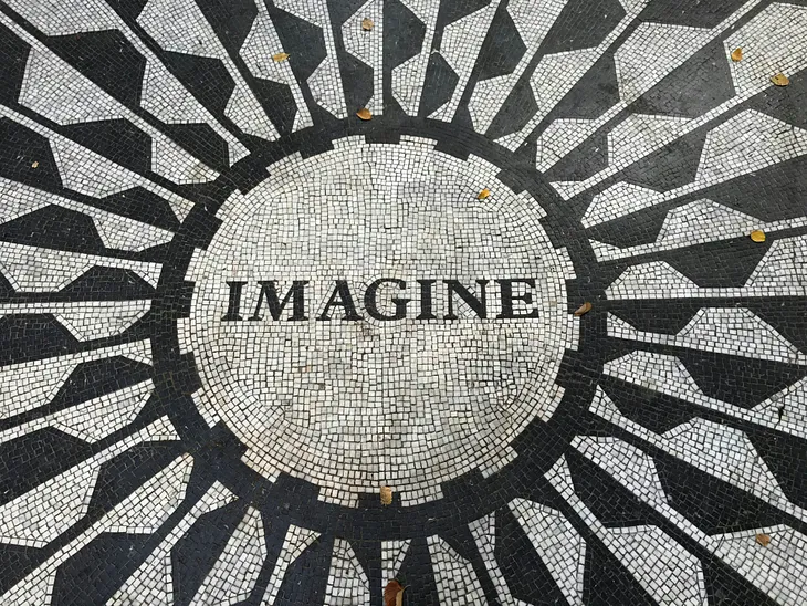 The word Imagine as black text inside a white circle on a black and white background