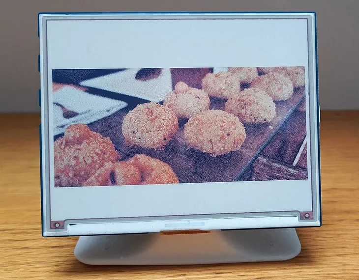 Color e-paper display on a small stand showing some cookies