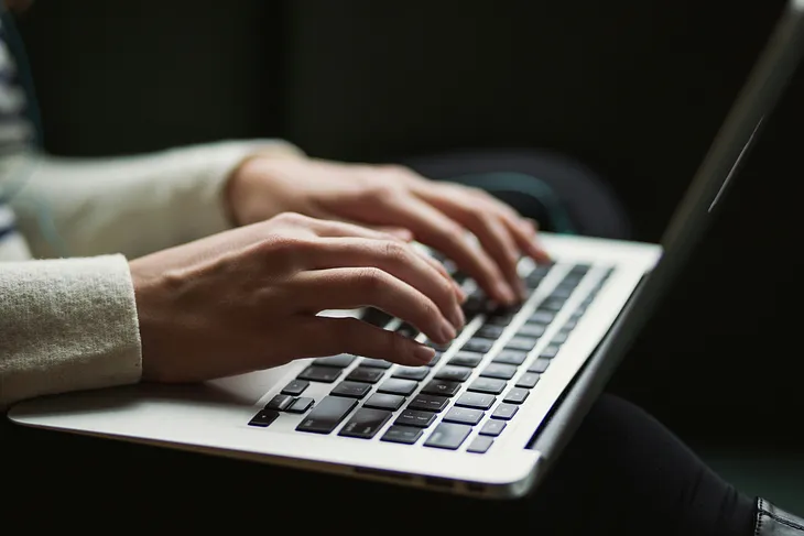 Hands typing on a laptop