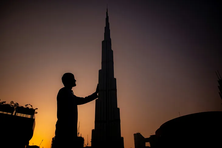 the shade of a man in front of a huge skyscraper (possibly in Dubai)