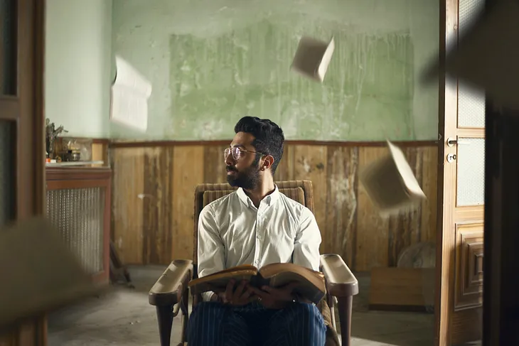 person holding book and other books in air