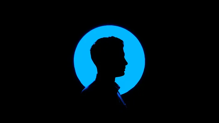 Side profile of a man in a blue spotlight