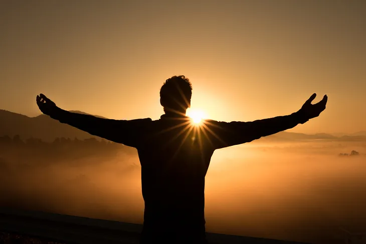 A-happy-man-on-the-cliff-witnessing-sunrise