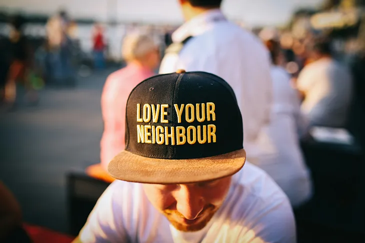 man wearing hat baseball hat that says love your neighbor