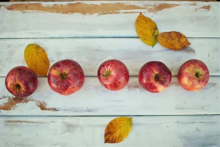 Five red apples in a horizontal line, slightly off kilter