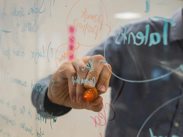 engineer teaching using a clear board to draw on