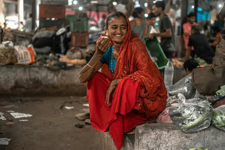 A South Asian woman is all smiles while sipping on chai