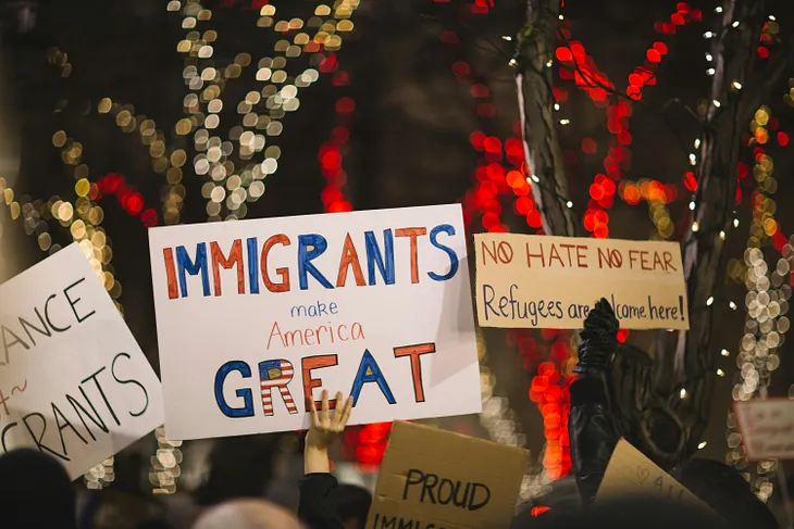 Cardboard signs saying ‘Immigrants make America great’.