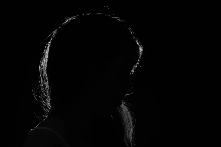 A black and white silhouette of a woman’s profile