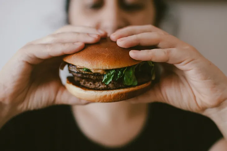 A woman’s eating burger