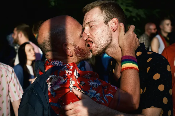 Two men kissing passionately.