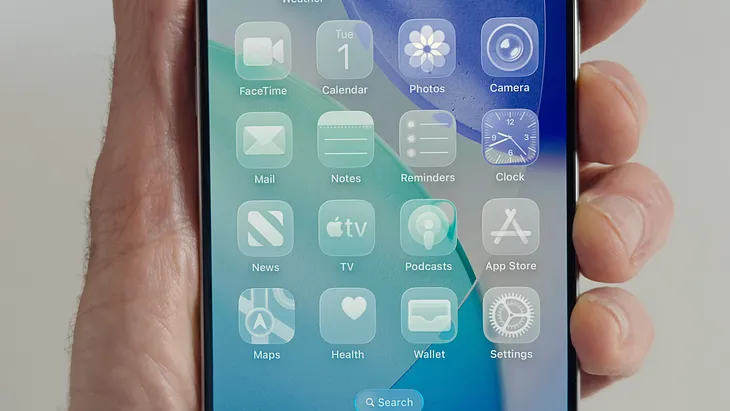 An iPhone screen filled with app icons on the transparent, Liquid Glass user interface.
