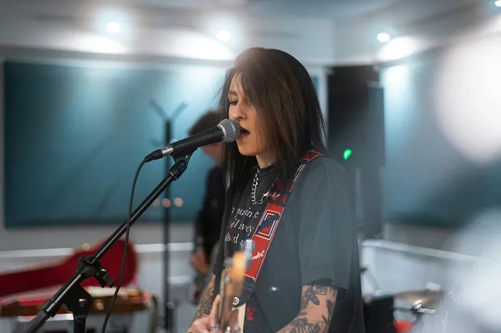 Female lead singer rehearsing with her band.