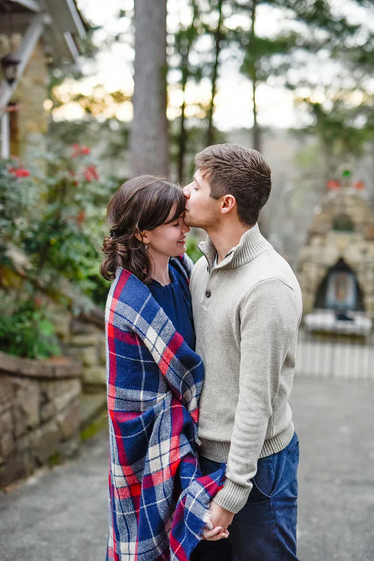 Here is a couple gently embracing each other, and the gentleman softly plants a kiss on her forehead, representing an apology after a silly argument.