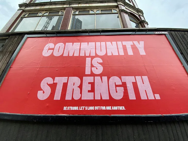 The writer pictures a sign that reads, “Community is Strength.”