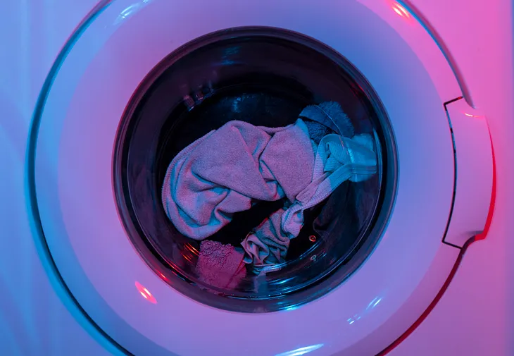 pink and purple coated washer machine with clothes in it