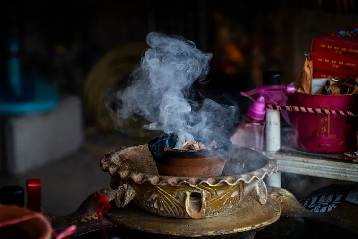 Incense burns at a signmaking shop in Bangkok’s Chinatown. Photo: Matt Hunt