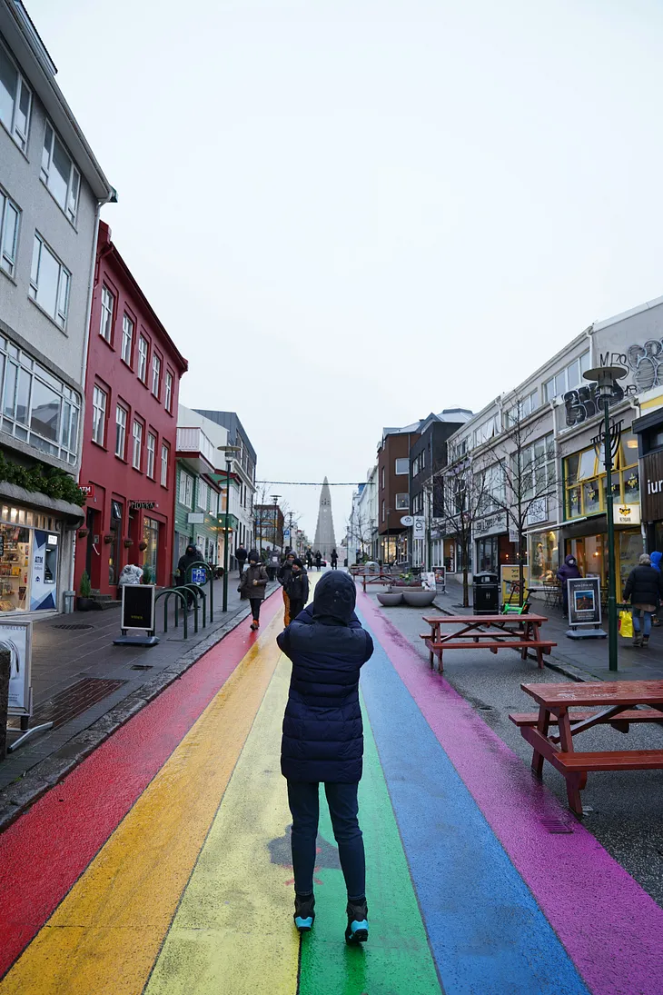 A rainbow street with people on it.