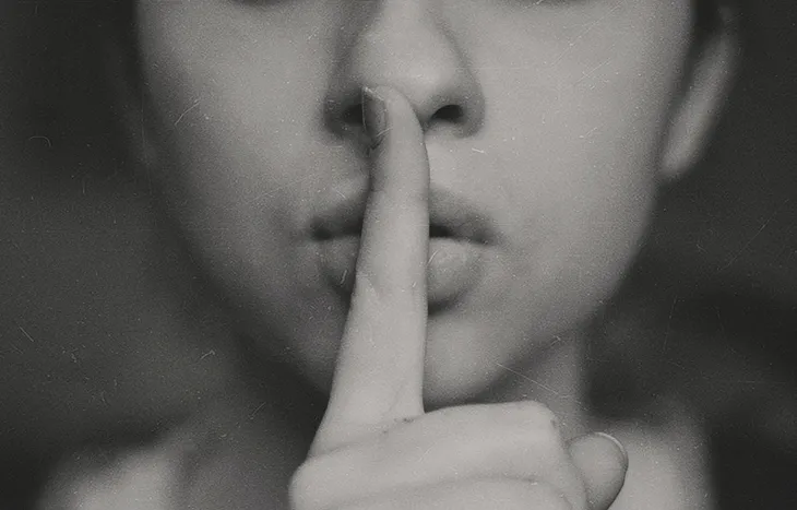 Person holding a finger to their lips