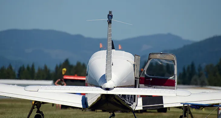 Photo of an airplane with an open door on the ground.