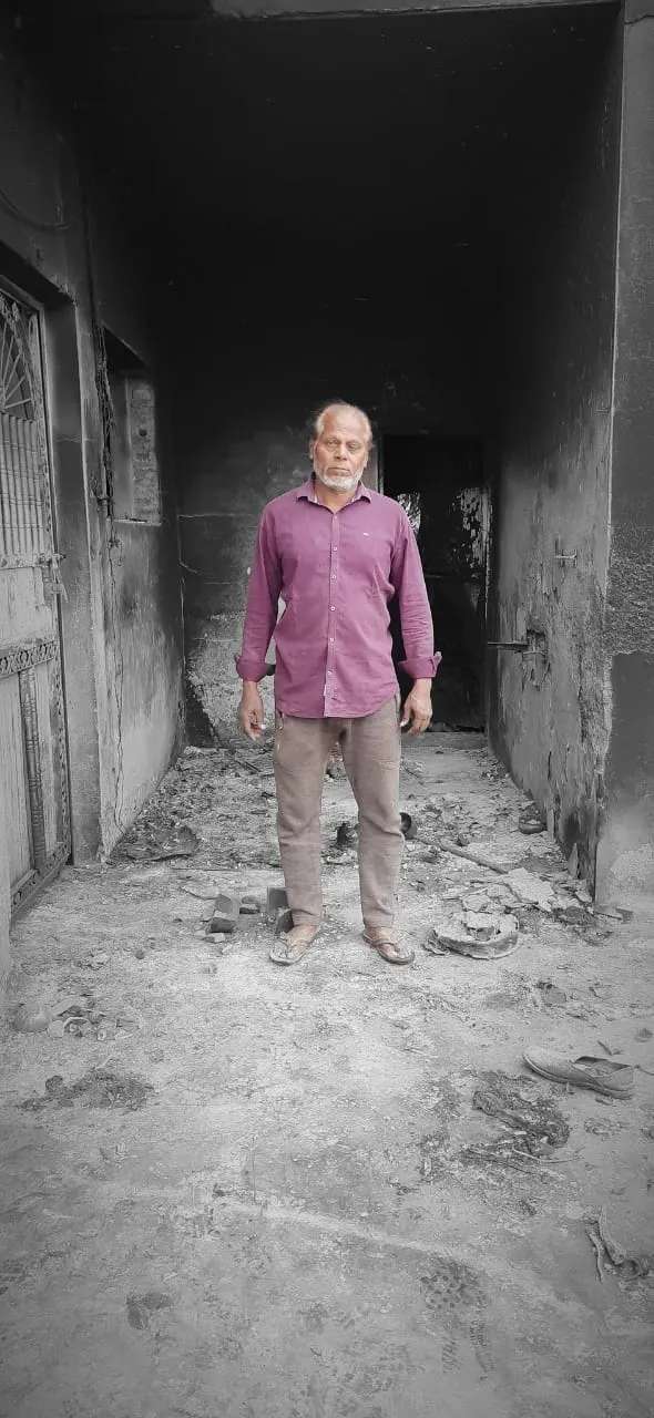 Roop Singh outside his burnt house.