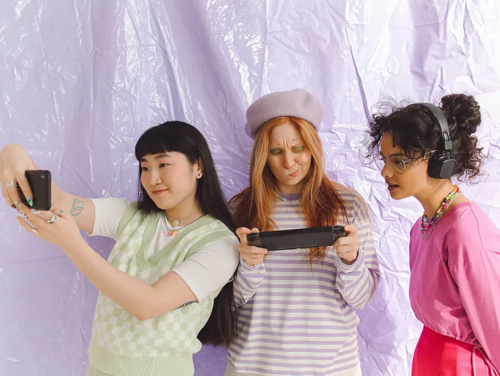 Three young ladies excitedly examining their first Fliki videos.