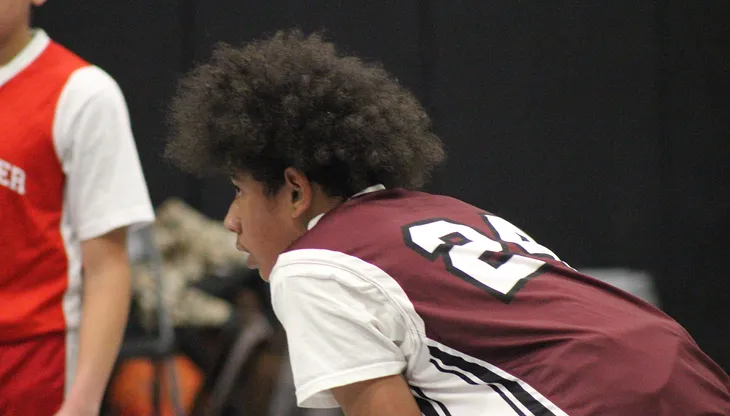 A player takes a breather from action in a recent middle school basketball game