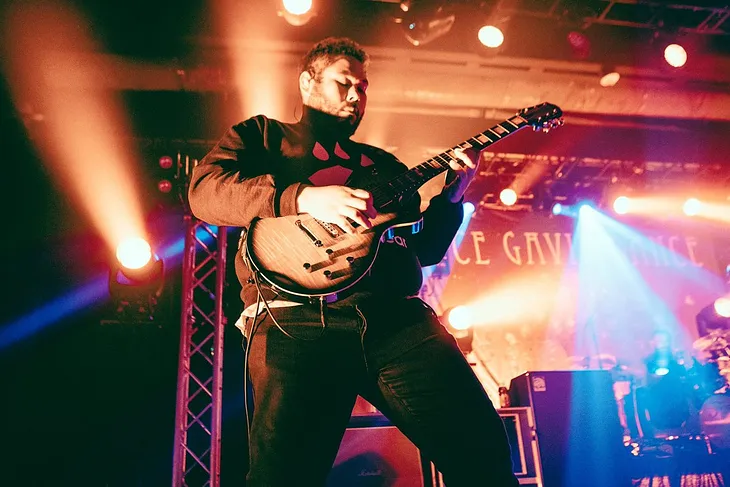 Dance Gavin Dance guitarist, Will Swan, playing guitar at a concert.