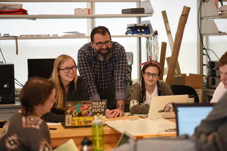 professor with students surrounding him.