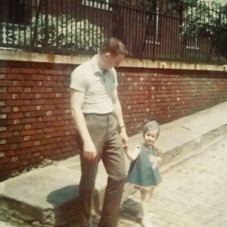 A young man walking his daughter across the street in the 1960’s Bronx