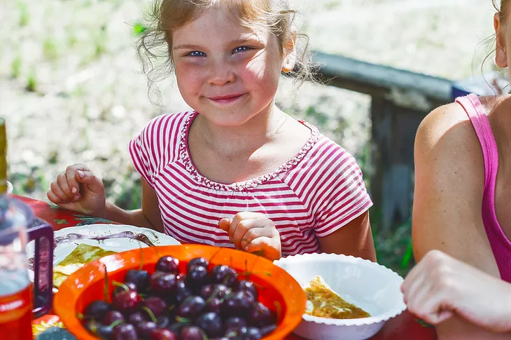 Little girl smiling on vacation traveling with multiple members in her family and enjoying simple foods that are also cost-efficient for her parents.