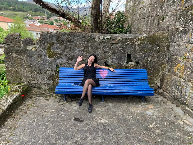 Young woman in a beautiful blue park bench with a pink heart, in Melgaço — Portugal