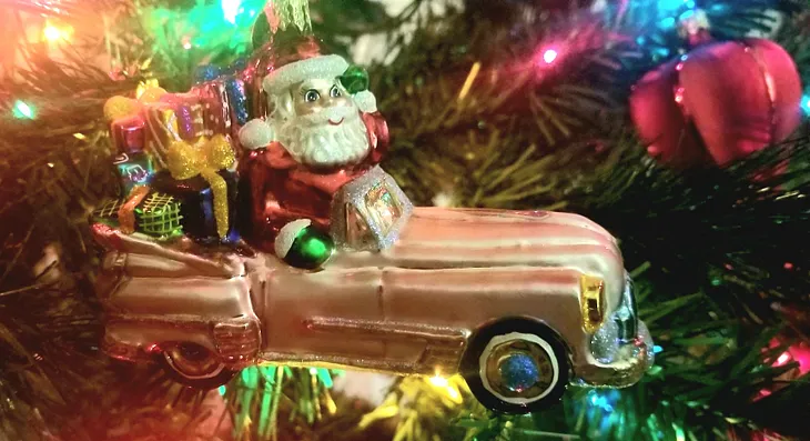 A vintage Christopher Radko Christmas ornament, Santa in a pink convertible