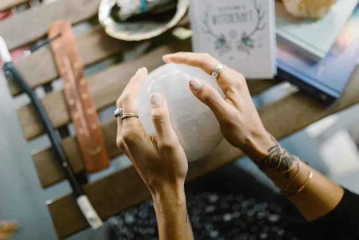 Photo by RDNE Stock project: https://www.pexels.com/photo/hands-holding-the-crystal-ball-on-the-wooden-table-6806746/