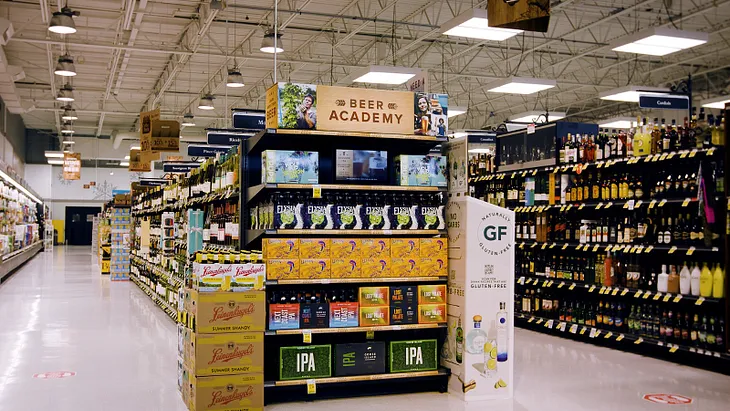 An educational display with a tablet playing content about beer, in a Schnucks Market grocery store.