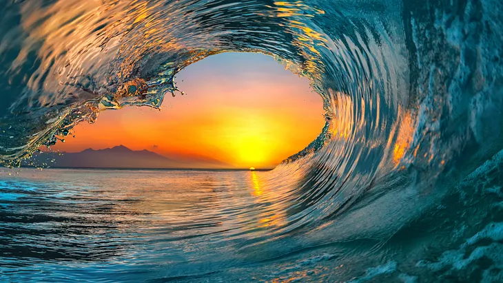 a sunset inside an ocean’s wave
