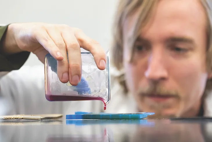 A researcher pours fluid into a tray.