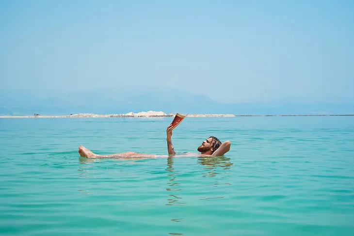 A man reading a book, while floating in the Dead Sea