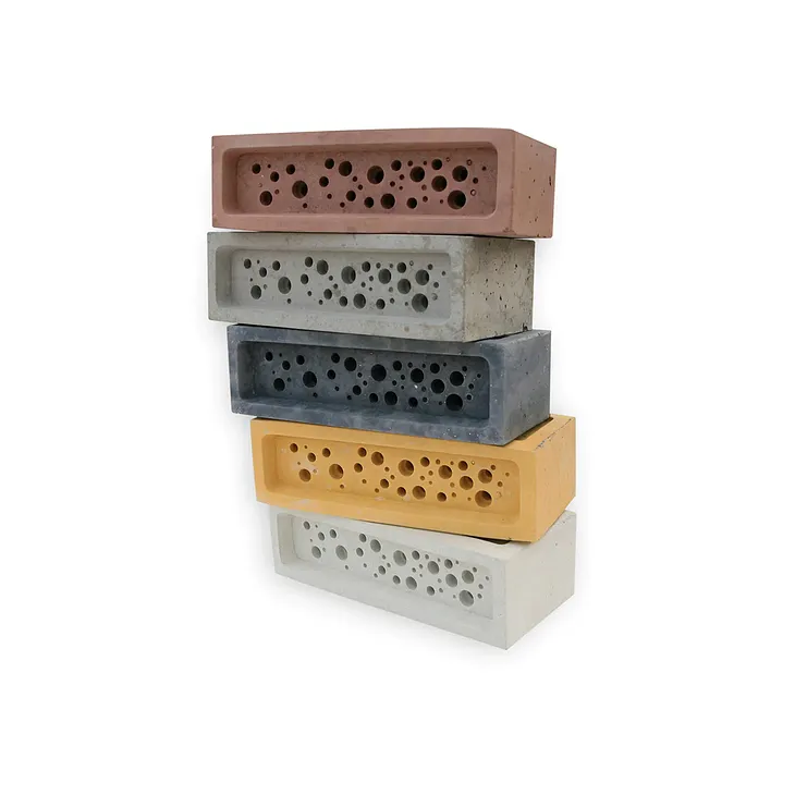A stack of bee bricks, bricks with holes in them for bees, in different colors of clay