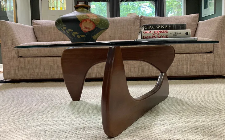Author photo of Noguchi table replica with vase and books in front of a sofa