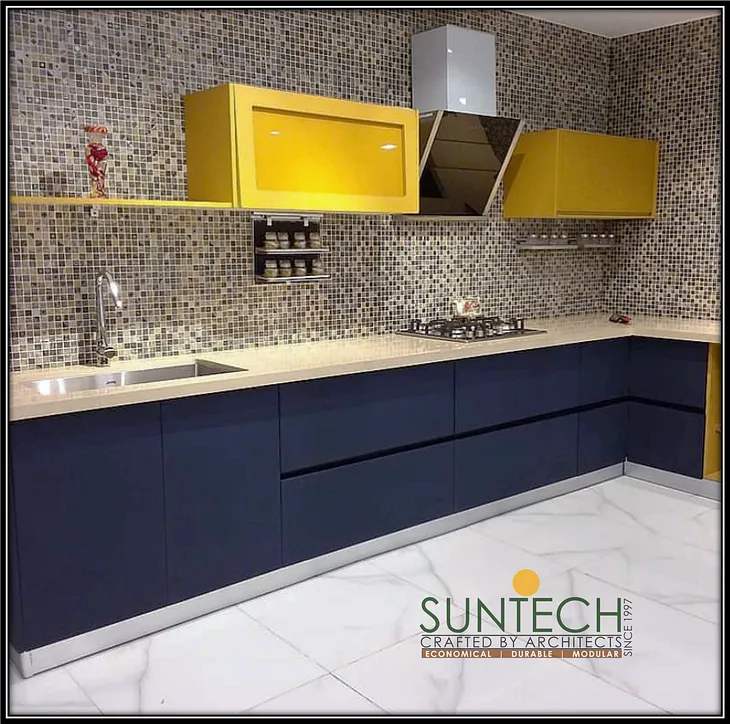 Yellow and blue modular kitchen with mozaic tiles by suntech interiors and modular kitchens