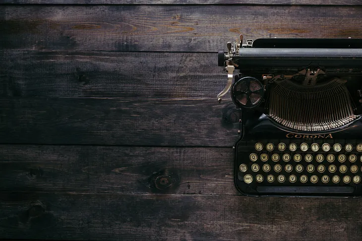 Antique typewriter on wooden desk from above