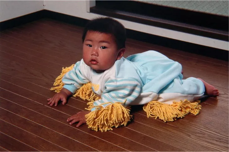 Baby clothes with mop rags attached to the hands and legs.